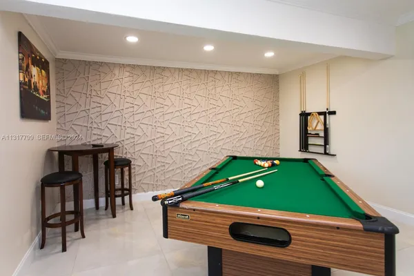 a room with pool table and windows
