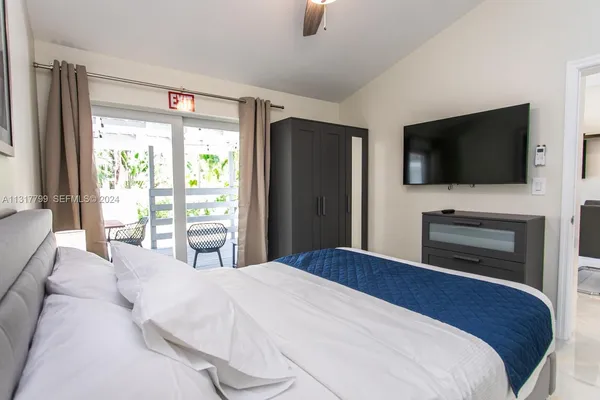 a bedroom with a bed and a flat screen tv