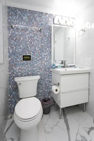 a bathroom with a toilet a sink and mirror