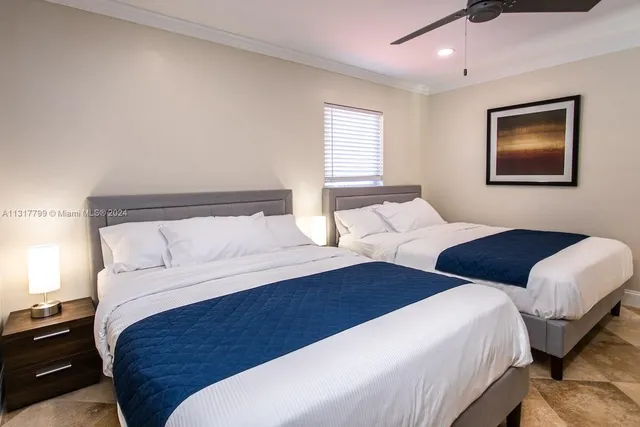 a bedroom with two beds and a window