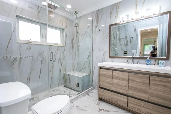 a bathroom with a double vanity sink toilet and shower