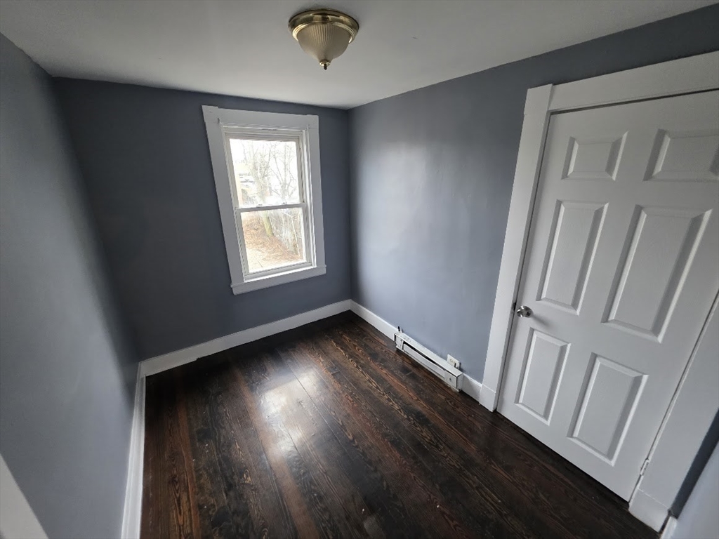 8 Dana, Unit 2 Boston, MA 02136 - Photo 7 of 9 an empty room with wooden floor and windows