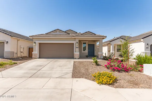 a front view of a house with a yard and potted plants