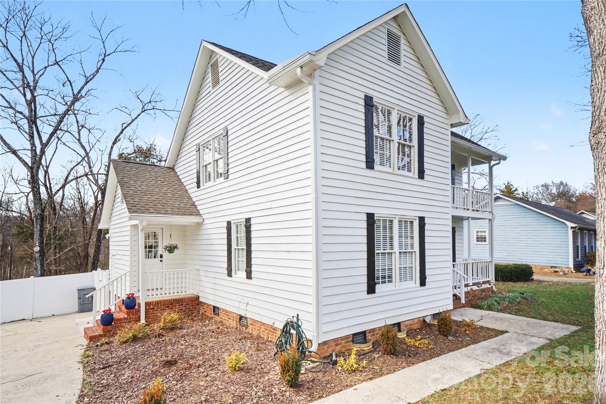 8330 Tifton Road Charlotte, NC 28226 - Photo 2 of 36 a view of a white house with a small yard and large tree