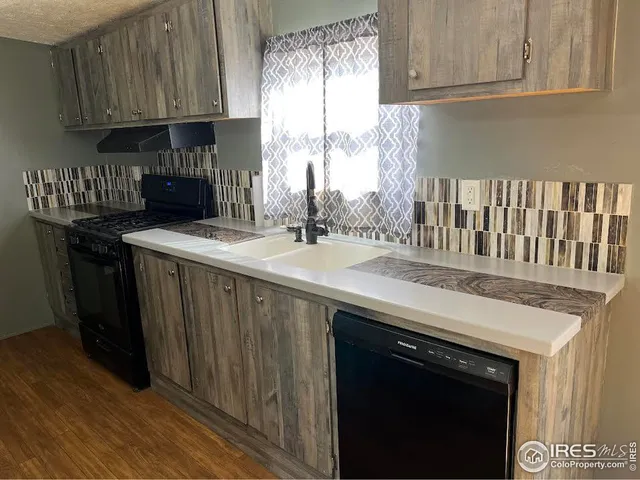 a kitchen with granite countertop a sink a stove and cabinets