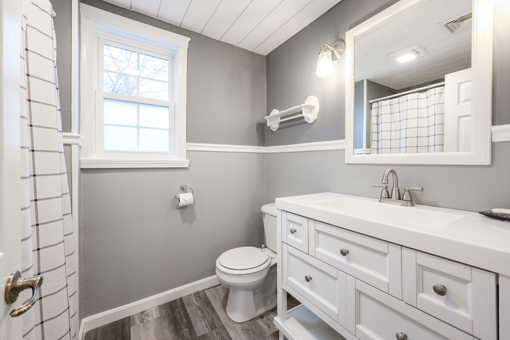 4 Roosevelt Street Wareham, MA 02571 - Photo 24 of 34 a bathroom with a granite countertop toilet a sink a mirror and a window