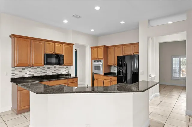 a view of an empty room with wooden floor and a ceiling fan