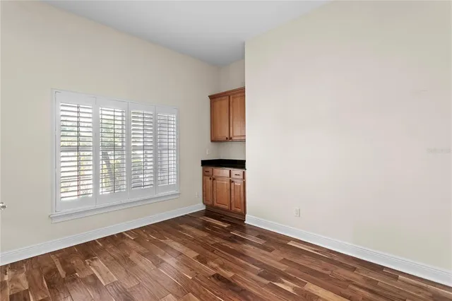 a view of kitchen with refrigerator stove and wooden floor