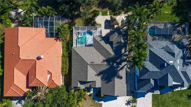 an aerial view of residential houses with outdoor space and trees