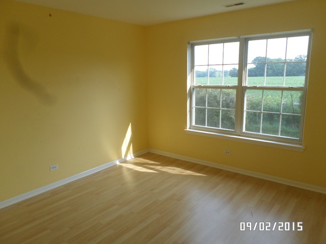 555 Willow Way Lindenhurst, IL 60046 - Photo 11 of 12 an empty room with wooden floor and windows