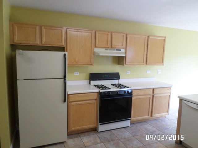 555 Willow Way Lindenhurst, IL 60046 - Photo 4 of 12 a kitchen with a stove top oven and refrigerator