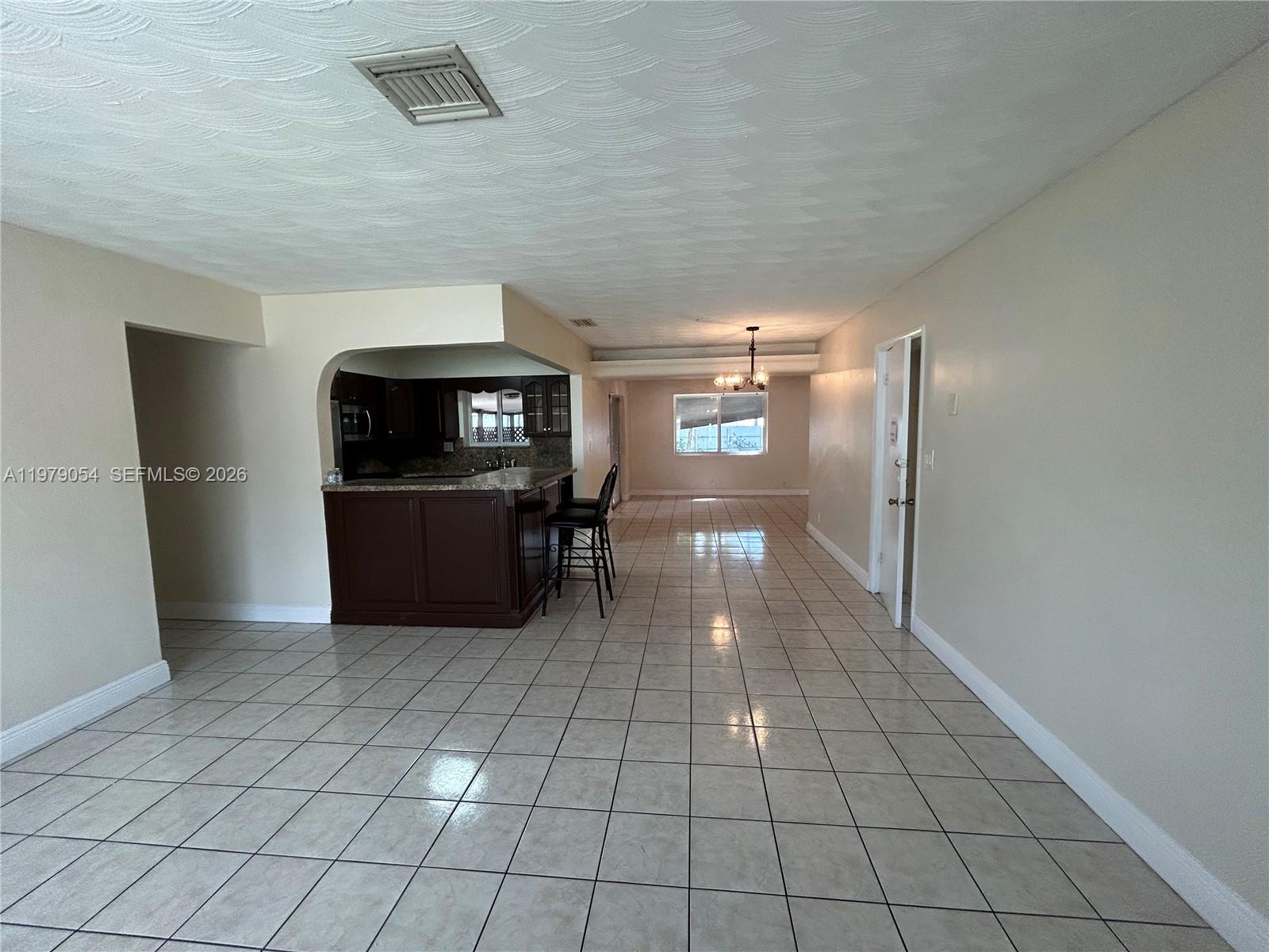 6614 Southwest 20th Street Miramar, FL 33023 - Photo 3 of 28 a view of a refrigerator in kitchen and an empty room and wooden floor