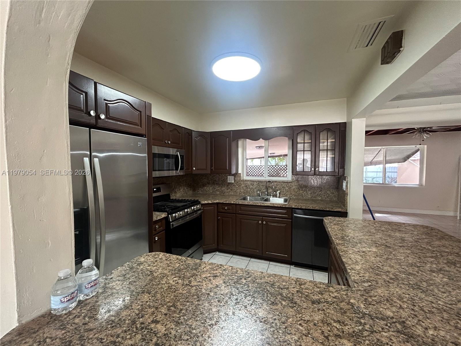 6614 Southwest 20th Street Miramar, FL 33023 - Photo 6 of 28 a kitchen with granite countertop a refrigerator stove and sink
