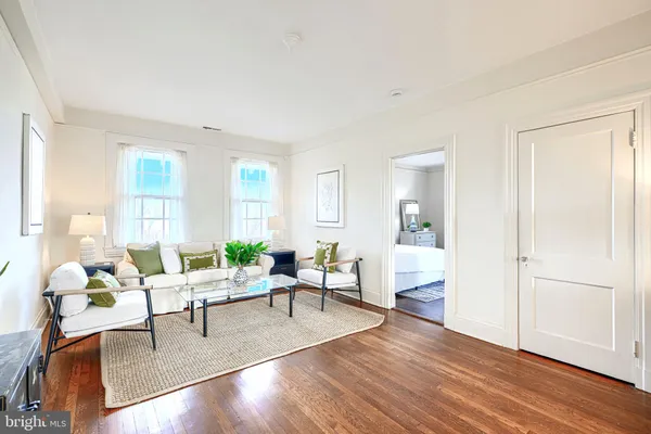 a living room with furniture flowerpot and wooden floor