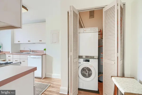 a kitchen with stainless steel appliances granite countertop a sink stove oven and white cabinets with wooden floor