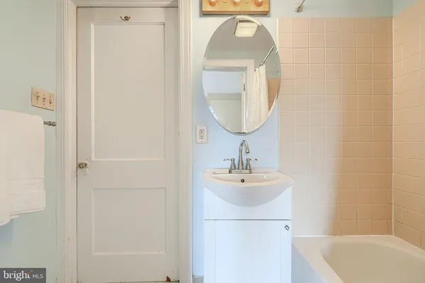 a bedroom with a bed a mirror on dresser and a window