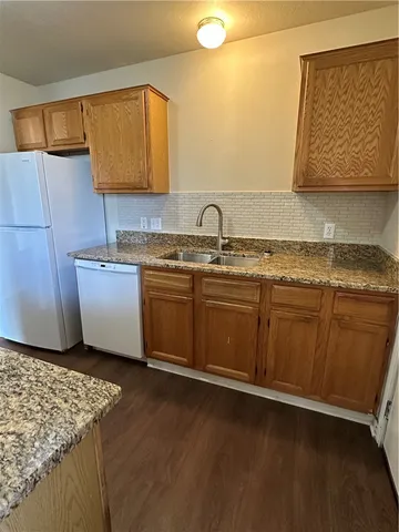 a kitchen with a sink cabinets and wooden floor
