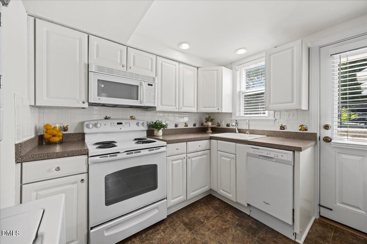 1627 Sutton Drive Raleigh, NC 27605 - Photo 9 of 33 a kitchen with cabinets appliances a sink and a window
