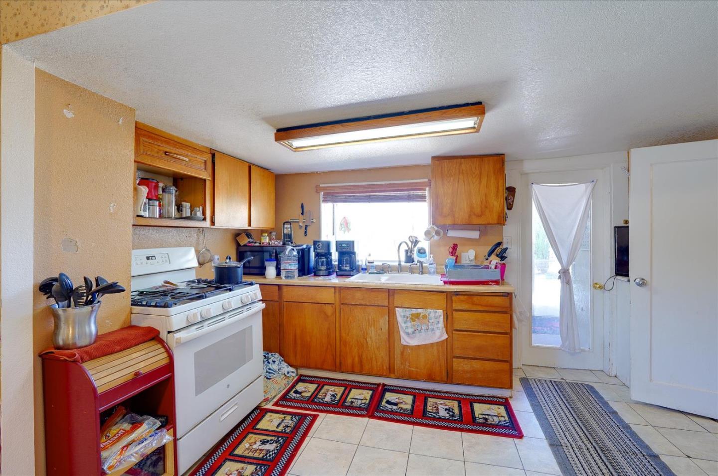 3040 Roop Road Gilroy, CA 95020 - Photo 16 of 63 a living room with furniture a rug and a refrigerator