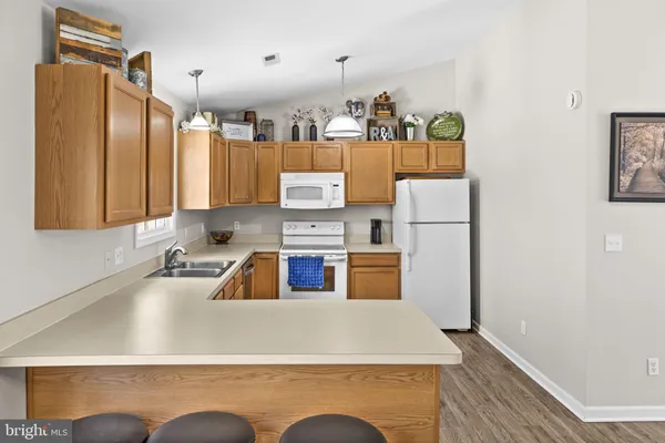 a kitchen with granite countertop cabinets stove top oven and microwave