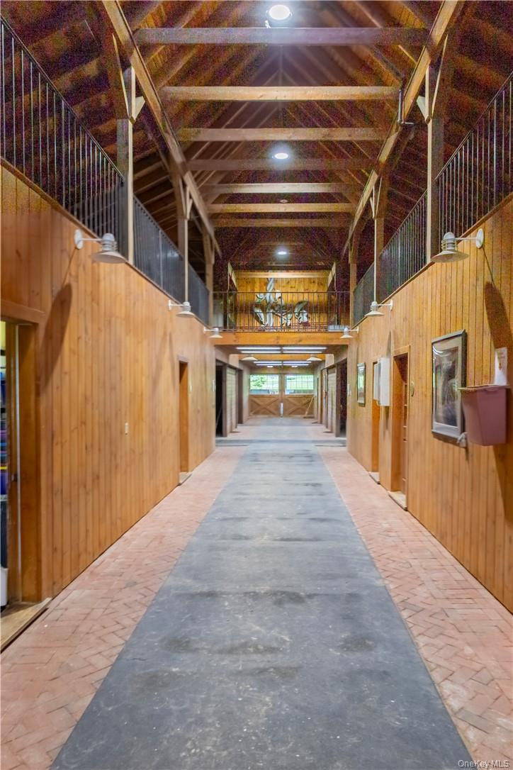 15 Kirby Hill Road Pawling, NY 12564 - Photo 13 of 37 The main barn center aisle, matted stalls, yoked windows, fire suppression system, automatic fly control system, climate-controlled tack room with kitchen and bathroom, feed storage, office and viewing room, bathrooms, 2 hot water wash stalls with heat lamps, 4 grooming stalls, hay loft with drop to each stall, and hay conveyor.