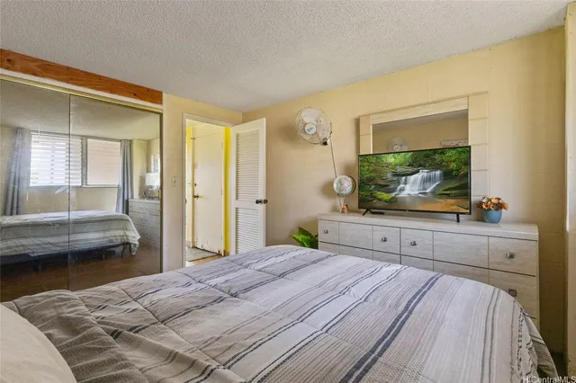 a bedroom with a bed and a flat screen tv