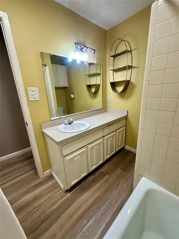 a bathroom with a double vanity sink a mirror and a bathtub