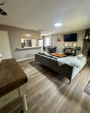 a large living room with stainless steel appliances granite countertop furniture a fireplace and a flat screen tv