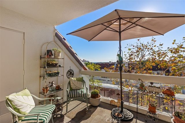 a view of a balcony with chairs and an umbrella