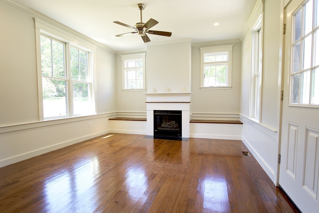 180 First Parish Road Scituate, MA 02066 - Photo 9 of 26 a view of a livingroom with wooden floor a fireplace and windows