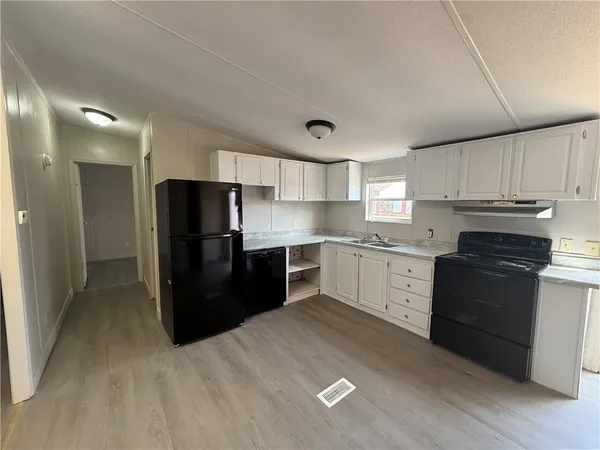 a kitchen with granite countertop a refrigerator and a stove top oven