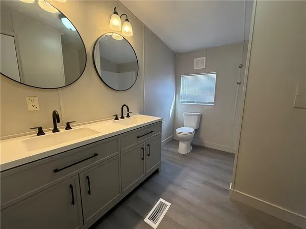 a en suite bathroom with a double vanity sink and a mirror