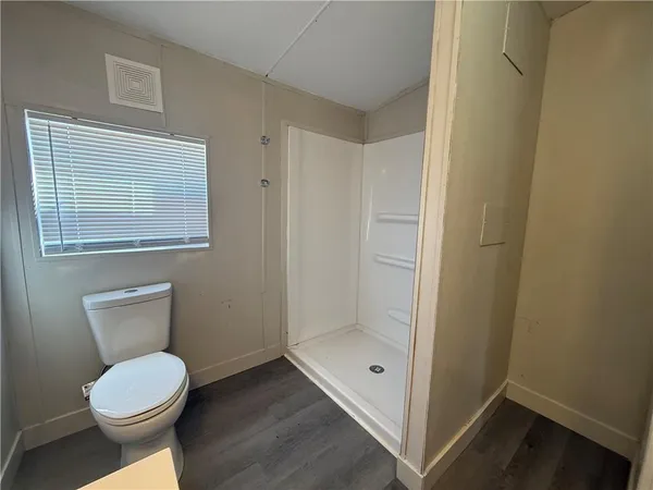 a bathroom with a toilet and a shower