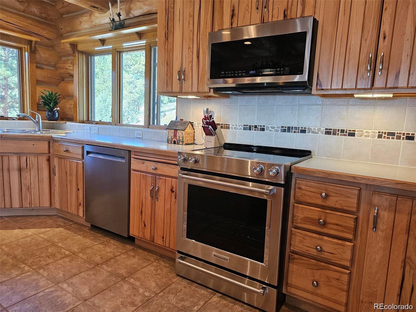 256 Blueberry Drive Bailey, CO 80421 - Photo 15 of 49 a kitchen with stainless steel appliances a stove a microwave a sink and cabinets
