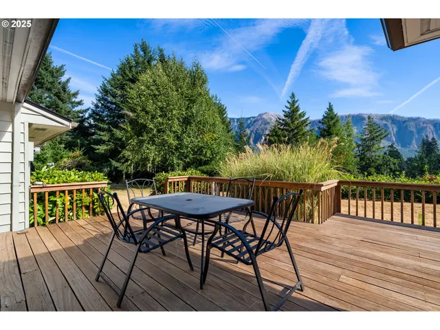 a view of a roof deck with table and chairs with wooden floor and fence