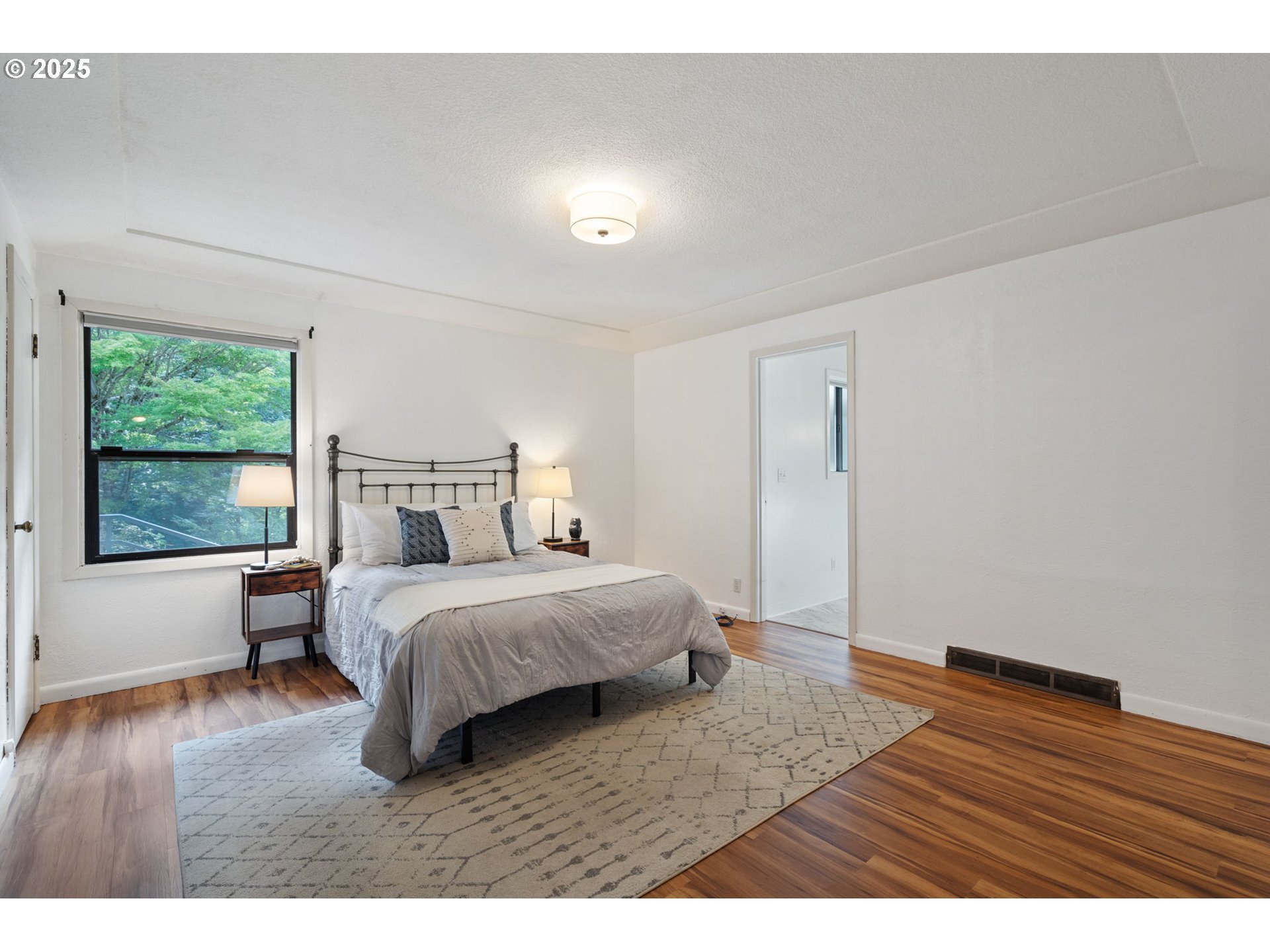 402 Skelton Road Stevenson, WA 98648 - Photo 18 of 48 a bedroom with a bed windows and wooden floor
