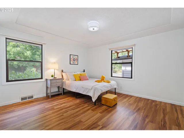 a bedroom with a bed and teddy bear on bed