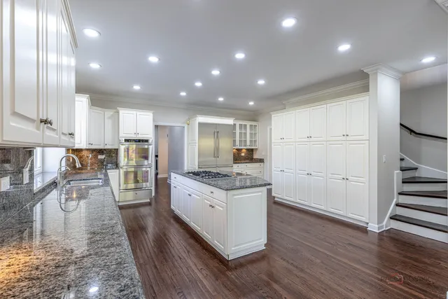 a kitchen with white cabinets and stainless steel appliances