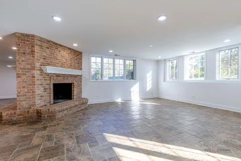 an empty room with windows and fireplace