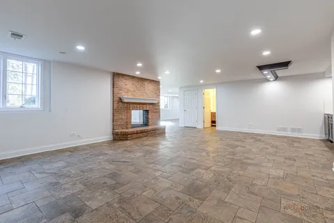 an empty room with windows and fireplace