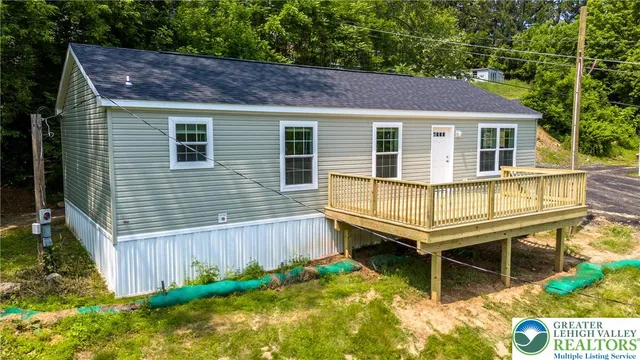 a backyard of a house with wooden deck and outdoor seating