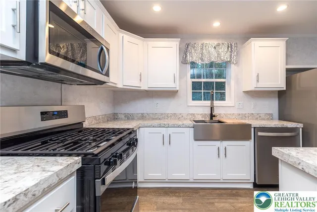 a kitchen with a stove a sink and a microwave