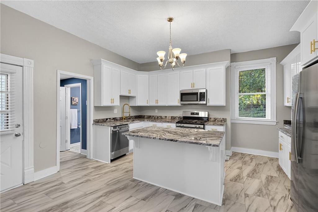 1331 Pritchard Street Pittsburgh, PA 15204 - Photo 13 of 49 a kitchen with stainless steel appliances granite countertop a stove top oven a refrigerator a sink and dishwasher with wooden floor
