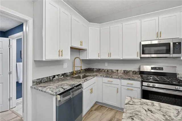 a kitchen with granite countertop a stove and a sink