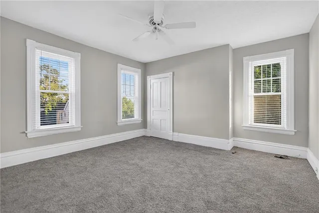an empty room with windows and closet