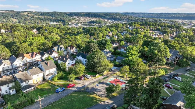 an aerial view of residential houses with outdoor space and trees