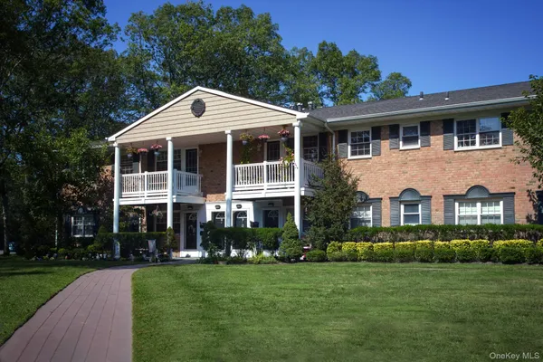 a front view of a house with a yard and green space