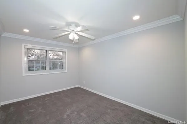 an empty room with a window and a fan