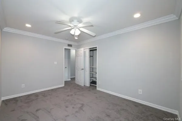 an empty room with a ceiling fan and a window