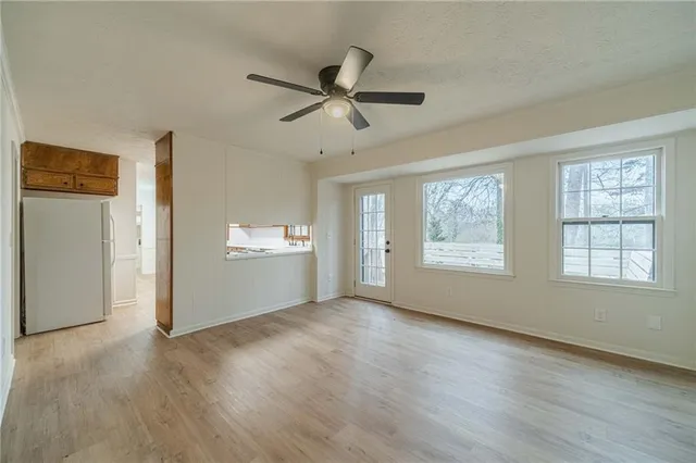 a view of an empty room with a window and wooden floor